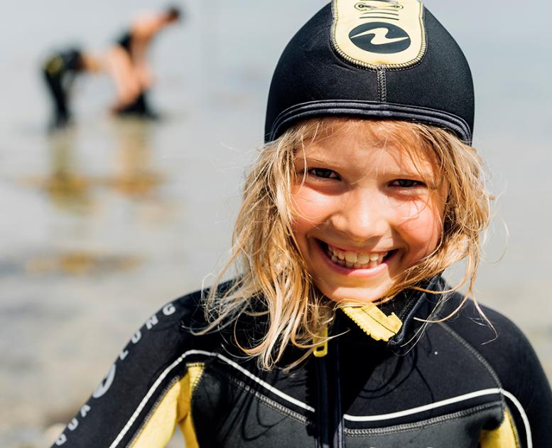 Barn på stranden klar til dykning